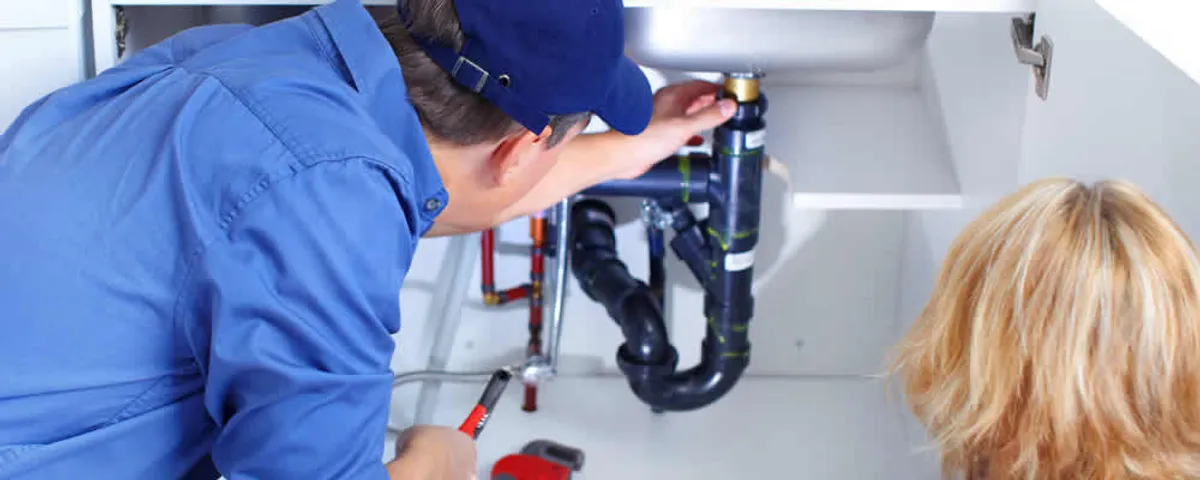 Plumber repairing under-sink drain pipes and fittings in Orange, CA